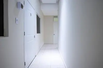 a hallway with white walls and a white tile floor at Suite 10 en la Zona Colonial in Santo Domingo
