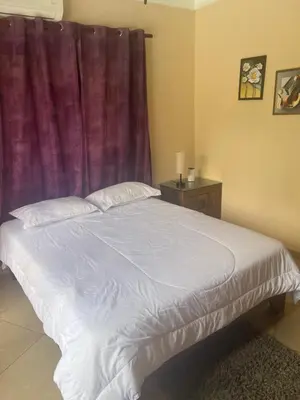 a bedroom with a white bed with a purple curtain at Casa Linda beautiful Villa in Sosúa