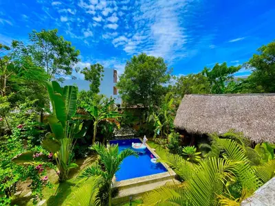 a resort with a swimming pool in a garden at Casita Chinola - Playa El Encuentro in Bombita
