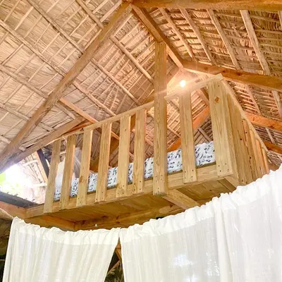 a wooden bed in a building with a roof at Casita de Madera Encuentro in Bombita