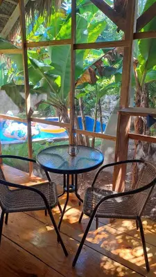 a table and two chairs and a table and a tree at Casita de Madera Encuentro in Bombita