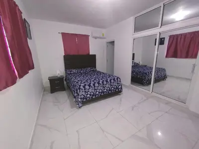 a bedroom with a bed and a mirror at Apartamento amueblado Res Blue Amber, 1 habitación in Santiago de los Caballeros