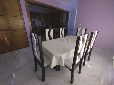 a dining room table and chairs with a white table cloth at Apartamento amueblado Res Blue Amber, 1 habitación in Santiago de los Caballeros