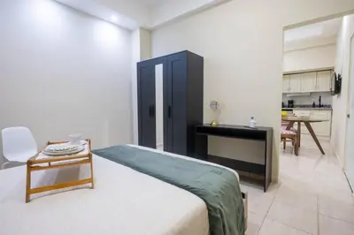 a bedroom with a bed and a table and a kitchen at Cozy Suite 8 en la Zona Colonial in Santo Domingo