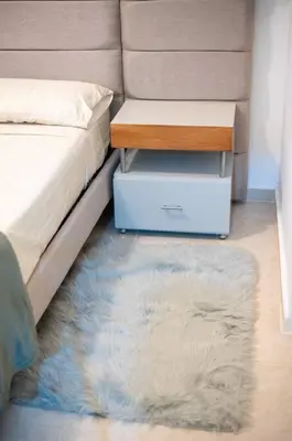 a bedroom with a bed with a nightstand and a rug at Estudio 9 en la Zona Colonial in Santo Domingo
