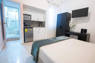 a small bedroom with a bed and a kitchen at Estudio 9 en la Zona Colonial in Santo Domingo