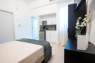 a small bedroom with a bed and a kitchen at Estudio 9 en la Zona Colonial in Santo Domingo