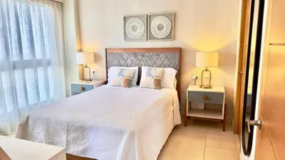 a bedroom with a large white bed with two lamps at Bello apartamento en Evaristo Morales, 1 BR in Santo Domingo
