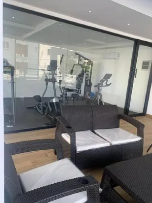 a room with a gym with a couch and exercise equipment at Bello apartamento en Evaristo Morales, 1 BR in Santo Domingo