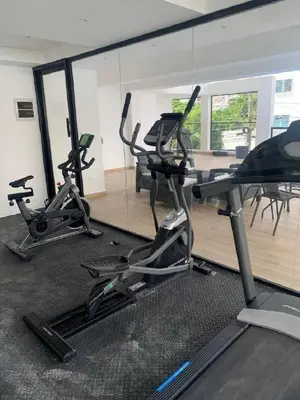 a gym with three exercise bikes in a room at Bello apartamento en Evaristo Morales, 1 BR in Santo Domingo