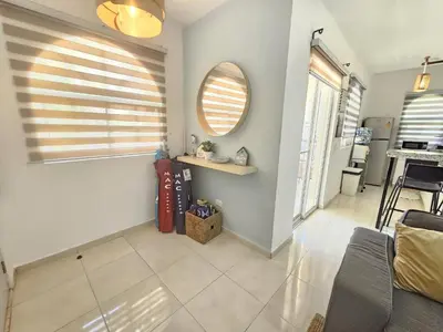 a living room with white walls and a mirror at Private Pool View 2BDR in Los Corales Punta Cana in Punta Cana