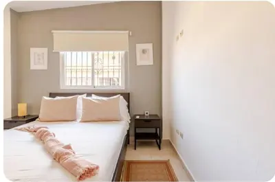 a bedroom with a large white bed with a window at Amplio apartmento in Santo Domingo