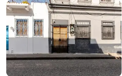 a white building with doors and windows on a street at Amplio apartmento in Santo Domingo