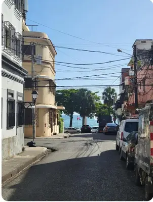 a street with cars parked on the side of the road at Amplio apartmento in Santo Domingo