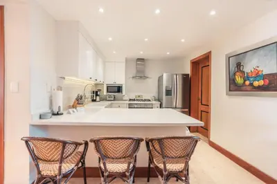 a kitchen with a island with four chairs in it at Magnificent Villa at Puerto Bahia in Sabana