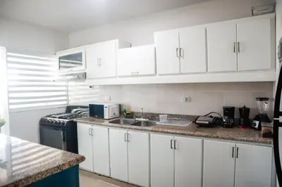 a kitchen with white cabinets and a sink at Salt Air & City Vibe Awaits! Just Minutes to Beach in San Felipe de Puerto Plata