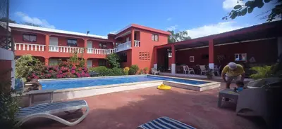 a man standing in front of a house with a swimming pool at Villa KIKI Ensenada in Punta Rucia