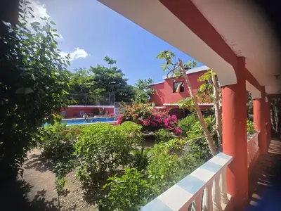 a house with a yard with flowers and a swimming pool at Villa KIKI Ensenada in Punta Rucia