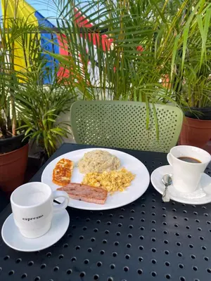 a table with a plate of food and two cups of coffee at Studio 27 Colonial, Centro Histórico in Santo Domingo
