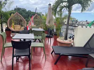 a patio with tables and chairs on a balcony at Studio 27 Colonial, Centro Histórico in Santo Domingo