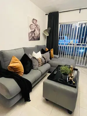 a living room with a gray couch and a table at Beautiful Condo in La Romana with pool near Caleta Beach in La Romana