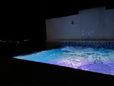a jacuzzi tub with blue and purple water at La Casita de Charo 2, vive y siente el amor, creando recuerdos de vida!! in Constanza