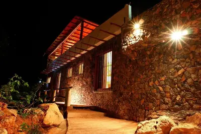 a stone building with a bench in front of it at night at Propiedad de alto standing con vista al mar, piscina, tenis, hasta 12 personas in Las Terrenas