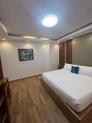 a bedroom with a large white bed with a blue pillow at Samaná Suites Hotel by Habita in Santa Bárbara de Samaná