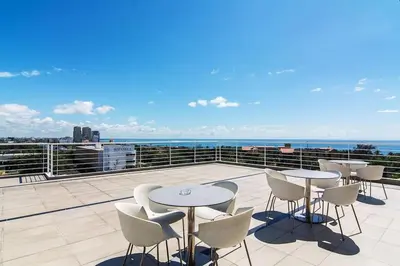 a patio with tables and chairs on a roof at Lincoln Suite Pool - Gym - Sauna in Santo Domingo