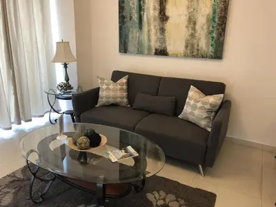 a living room with a couch and a glass table at Lincoln Suite Pool - Gym - Sauna in Santo Domingo