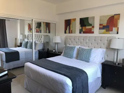 a large bedroom with two beds and mirrors at Lincoln Suite Pool - Gym - Sauna in Santo Domingo