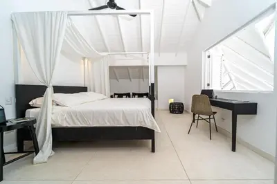 a bedroom with a bed and a desk and a bed sidx sidx sidx at Casa Panamera- 5br luxury beach Villa Playa Coson in Las Terrenas