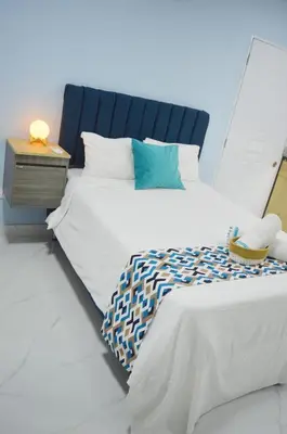 a bedroom with two twin beds and a night stand at Apartamento Amueblado Caribe, Santo Domingo a 10 minutos del Aeropuerto Internacional de las Americas in Santo Domingo