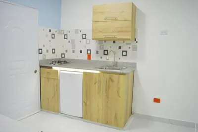 a kitchen with wooden cabinets and a sink at Apartamento Amueblado Caribe, Santo Domingo a 10 minutos del Aeropuerto Internacional de las Americas in Santo Domingo