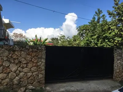 a stone fence with a black gate on a stone wall at Apartamento Amueblado Caribe, Santo Domingo a 10 minutos del Aeropuerto Internacional de las Americas in Santo Domingo