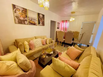 a living room with two couches and a table at Acogedora casa de 2 habitaciones in Villa Isabela