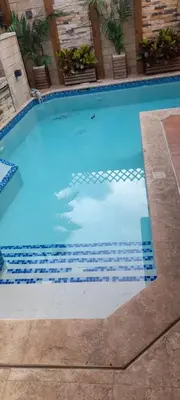 a large swimming pool with blue tiles on it at Villa Isabel, NO SMOKING, cerca embajada USA in Santo Domingo
