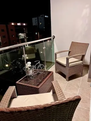 a balcony with wicker chairs and a table and a chair at Outstanding Pent House w/Jacuzzi in Santiago de los Caballeros