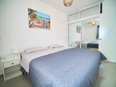 a white bedroom with a bed and a mirror at Mar Azul in Bayahibe