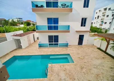 a house with a swimming pool in front of a building at Mar Azul in Bayahibe