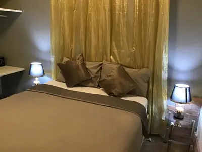 a bedroom with a bed with two lamps on tables at El Conde De Atrini in Santo Domingo