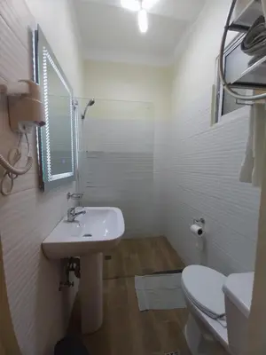 a white bathroom with a sink and a toilet at El Conde De Atrini in Santo Domingo
