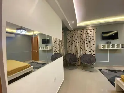 a room with a bed and two chairs in it at Privada tipo cabaña Con amplio patio in Santiago de los Caballeros