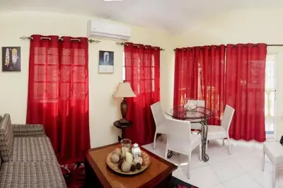 a living room with red curtains and a table at Apartamento en la Romana 2 días en adelante in La Romana