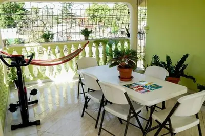 a dining room with a white table and white chairs at Apartamento en la Romana 2 días en adelante in La Romana