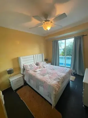 a bedroom with a bed and a ceiling fan at Dpto Dream Village Boca Chica frente a la playa in Boca Chica