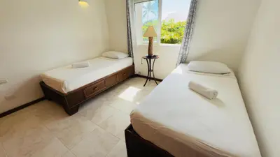 two beds in a room with a window at Don Cesar Beachfront Apartments in Las Terrenas