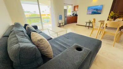a living room with a blue couch and a table at Don Cesar Beachfront Apartments in Las Terrenas