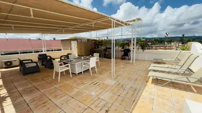 a patio with a table and chairs on a roof at Don Cesar Beachfront Apartments in Las Terrenas