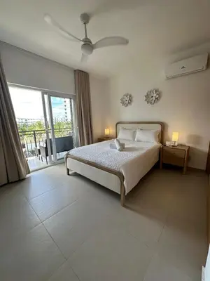 a bedroom with a bed and a large window at Esprit Caribbean Bayahibe in Bayahibe